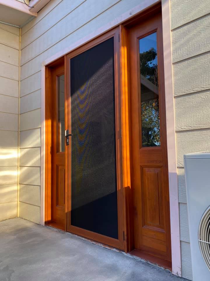 Hinged wooden door and ScreenGuard security screen door with sidelights on front entrance installed by Olsen Security