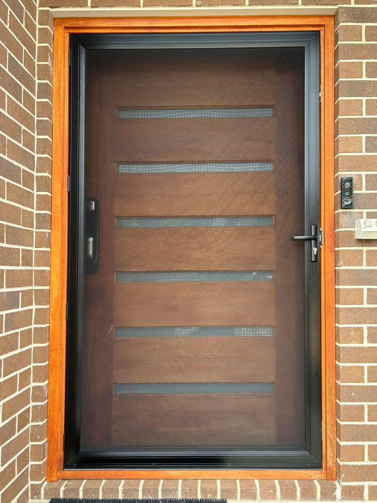 Hinged wooden entrance door and heavy-duty security mesh door installed by Olsen Security