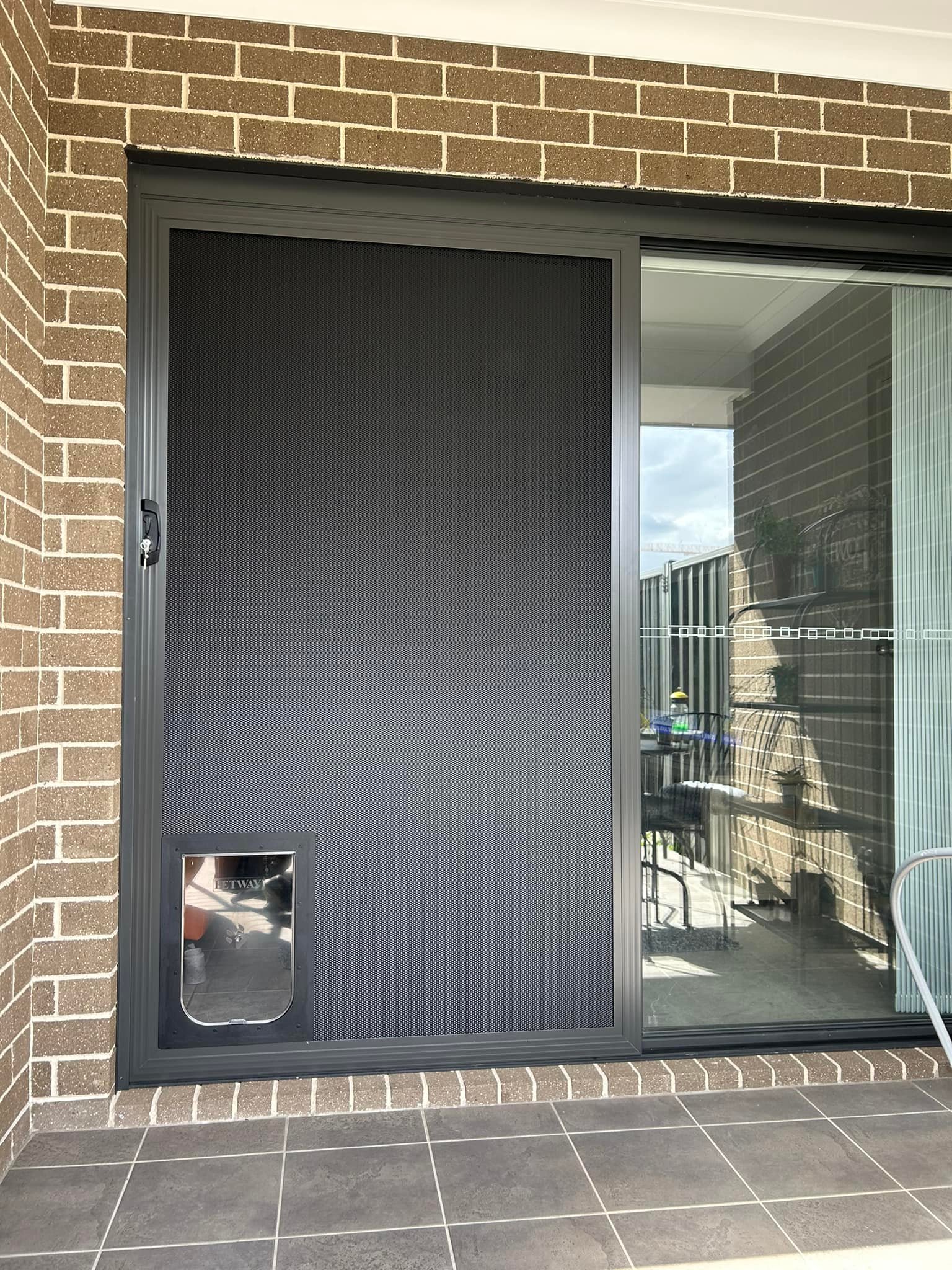 Sliding door with heavy-duty flyscreen door and pet door installed by Olsen Security