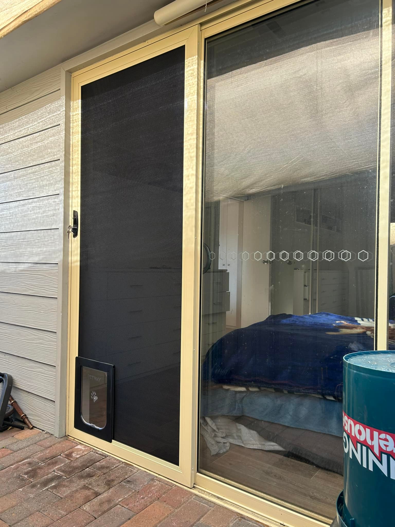 Sliding door with heavy-duty flyscreen door and pet door installed by Olsen Security
