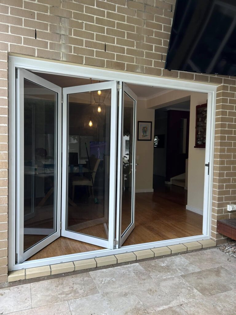 Stacker doors opening to outdoor patio installed by Olsen Security