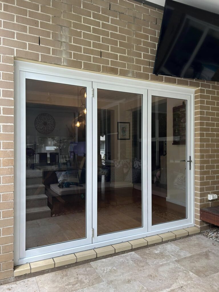 Stacker doors opening to outdoor patio installed by Olsen Security