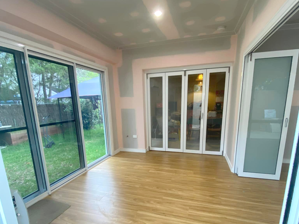 JDS Construction & Design - Stacker doors opening to adjoining living rooms, and ScreenGuard security sliding doors on sliding doors opening to outdoor area installed by Olsen Security