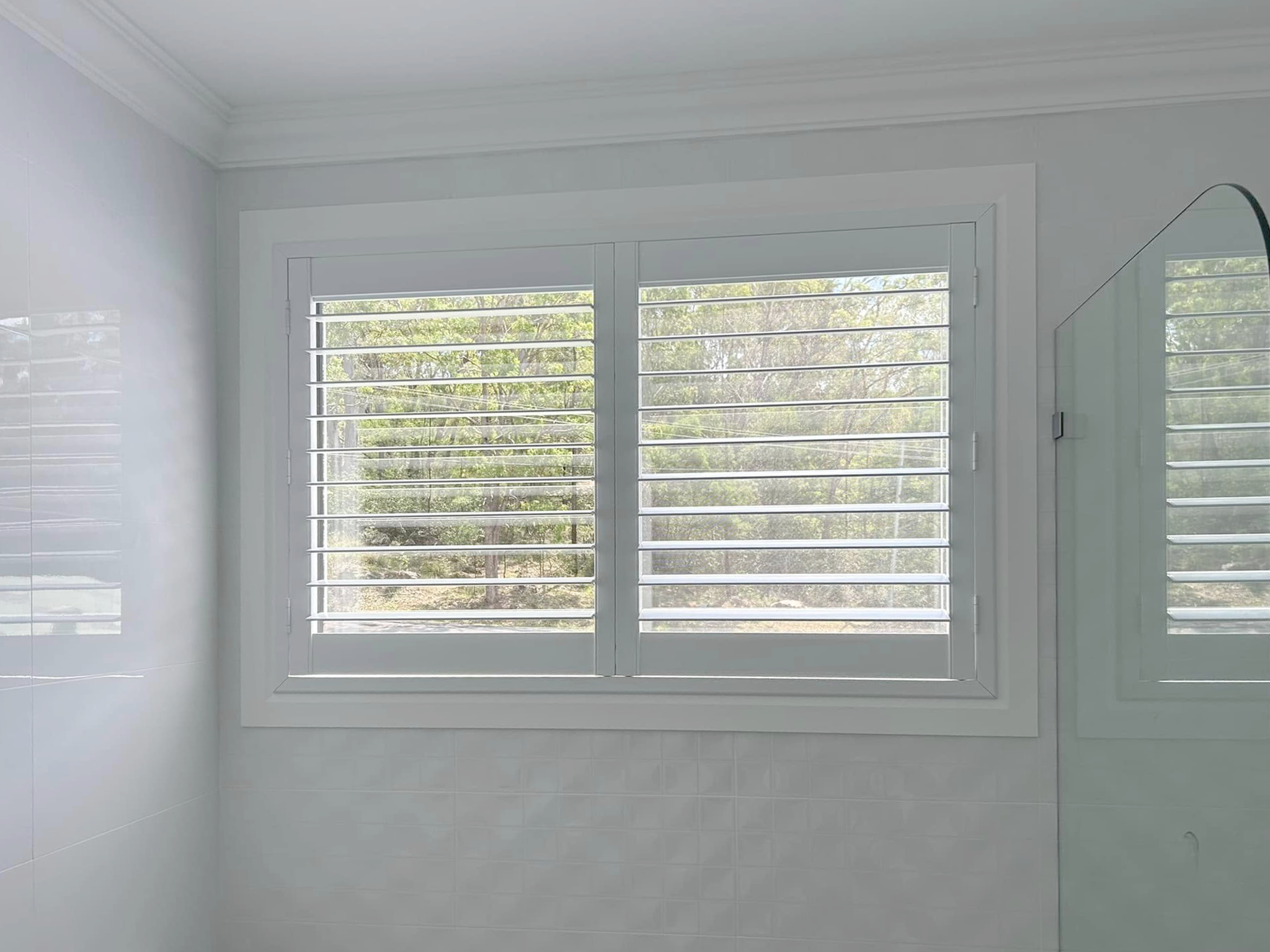 Plantation shutters, blinds, shades & privacy screens Plantation shutters on sliding windows in bathroom installed by Olsen Security