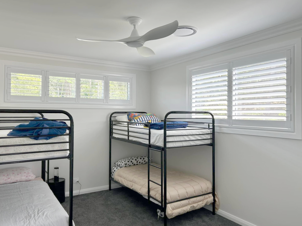 Plantation shutters, blinds, shades & privacy screens Plantation shutters on sliding windows in bedroom installed by Olsen Security