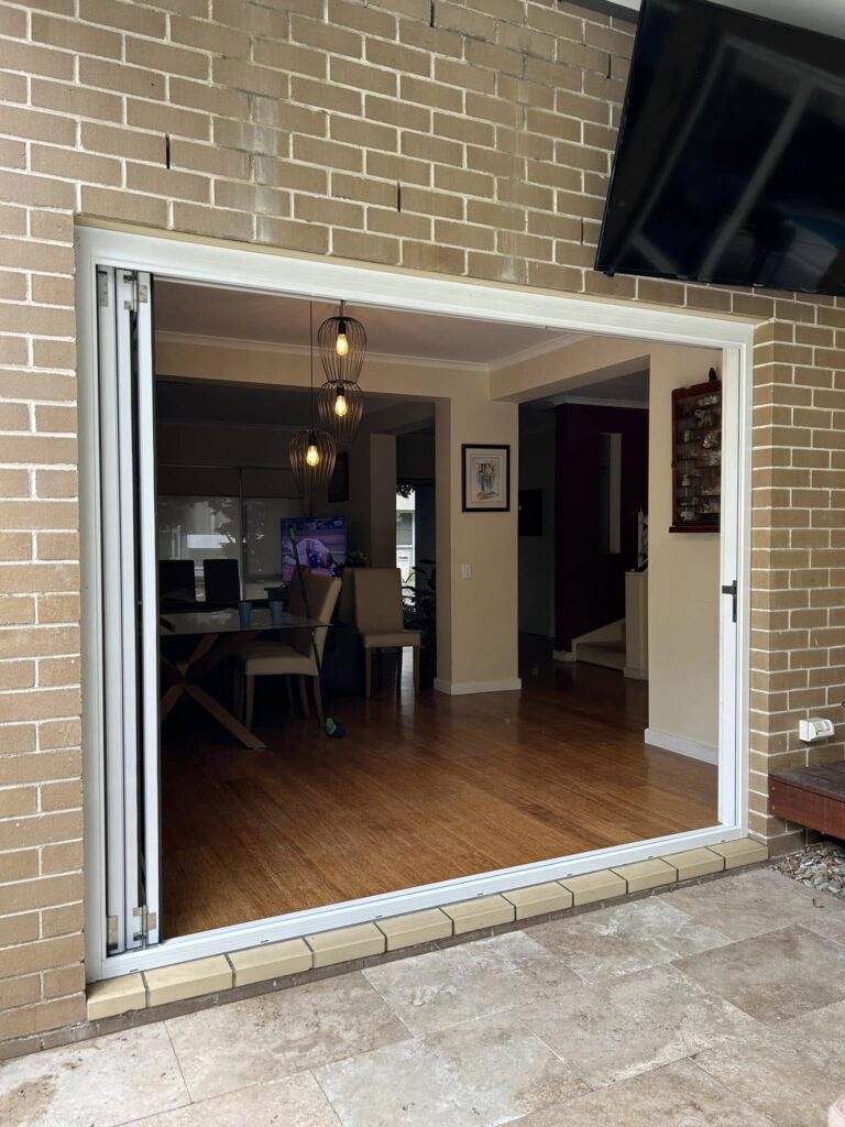 Stacker doors opening to outdoor patio installed by Olsen Security