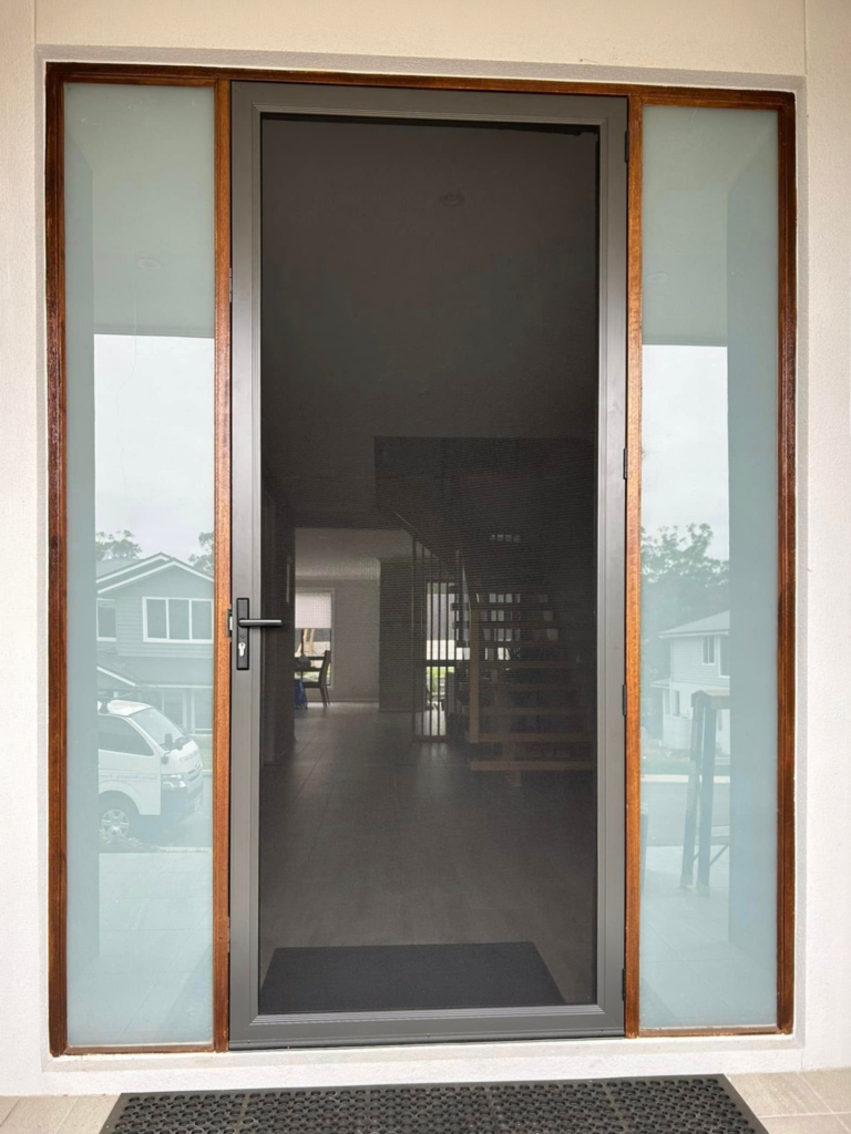 Hinged wooden entrance door and heavy-duty security mesh door with sidelights installed by Olsen Security