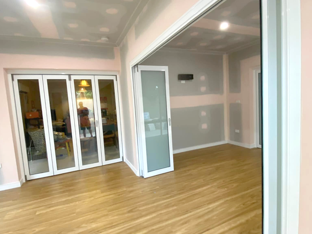 JDS Construction & Design - Stacker doors opening to adjoining living rooms, and ScreenGuard security sliding doors on sliding doors opening to outdoor area installed by Olsen Security