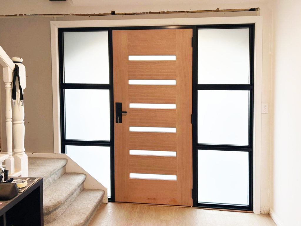 Hinged wooden door on front entrance with sidelights installed by Olsen Security
