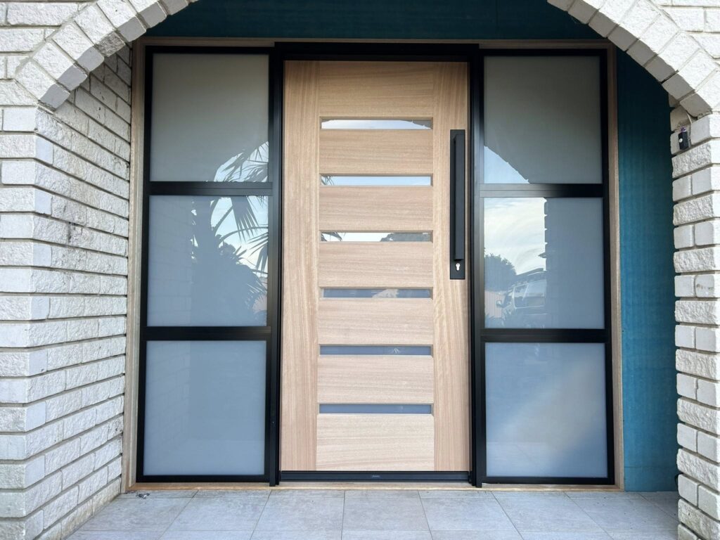 Hinged wooden door on front entrance with sidelights installed by Olsen Security