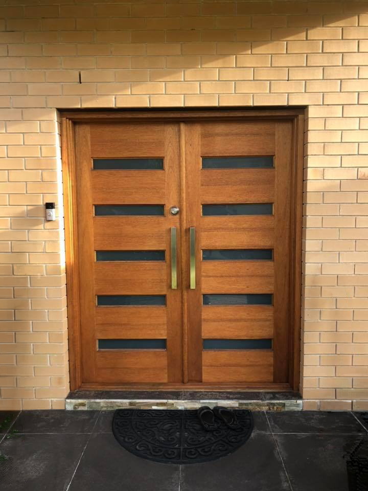 Hinged wooden doors on front entrance installed by Olsen Security