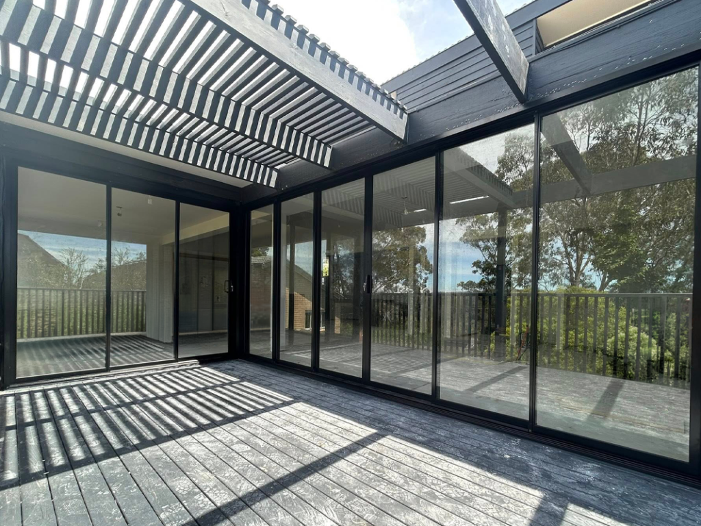 Corner stacking doors for living room opening out to deck installed by Olsen Security for Renovate Instyle project.