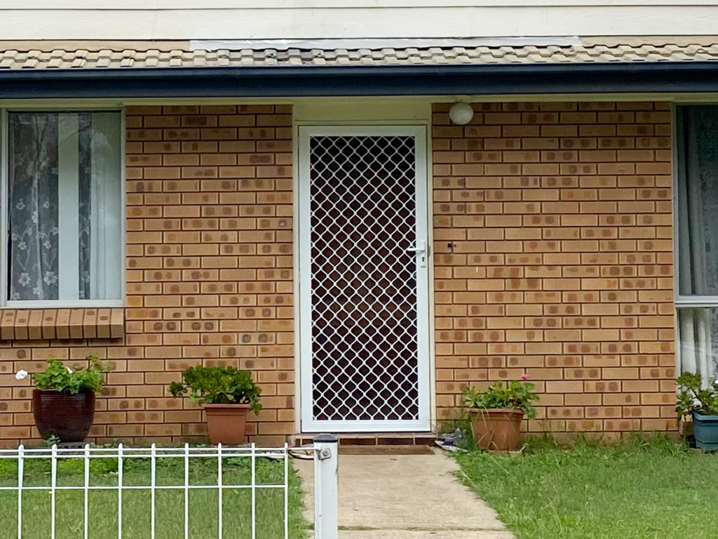 Security grill door with mesh on front entrance with sidelights installed by Olsen Security
