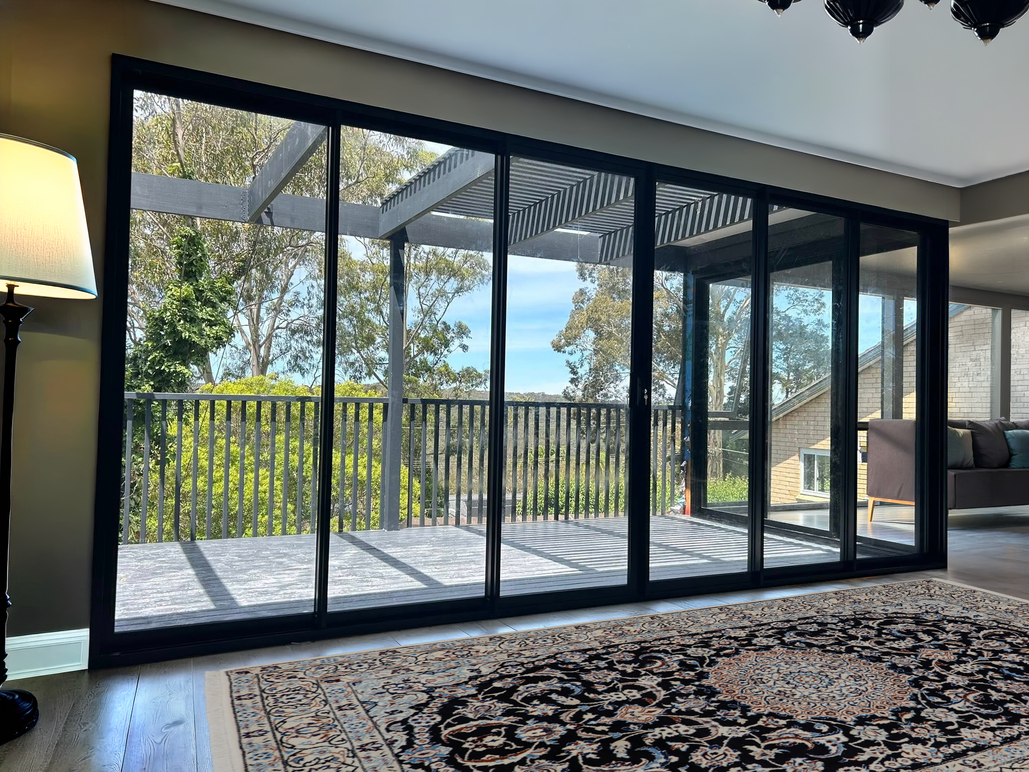 Corner stacking doors for living room opening out to deck installed by Olsen Security for Renovate Instyle project