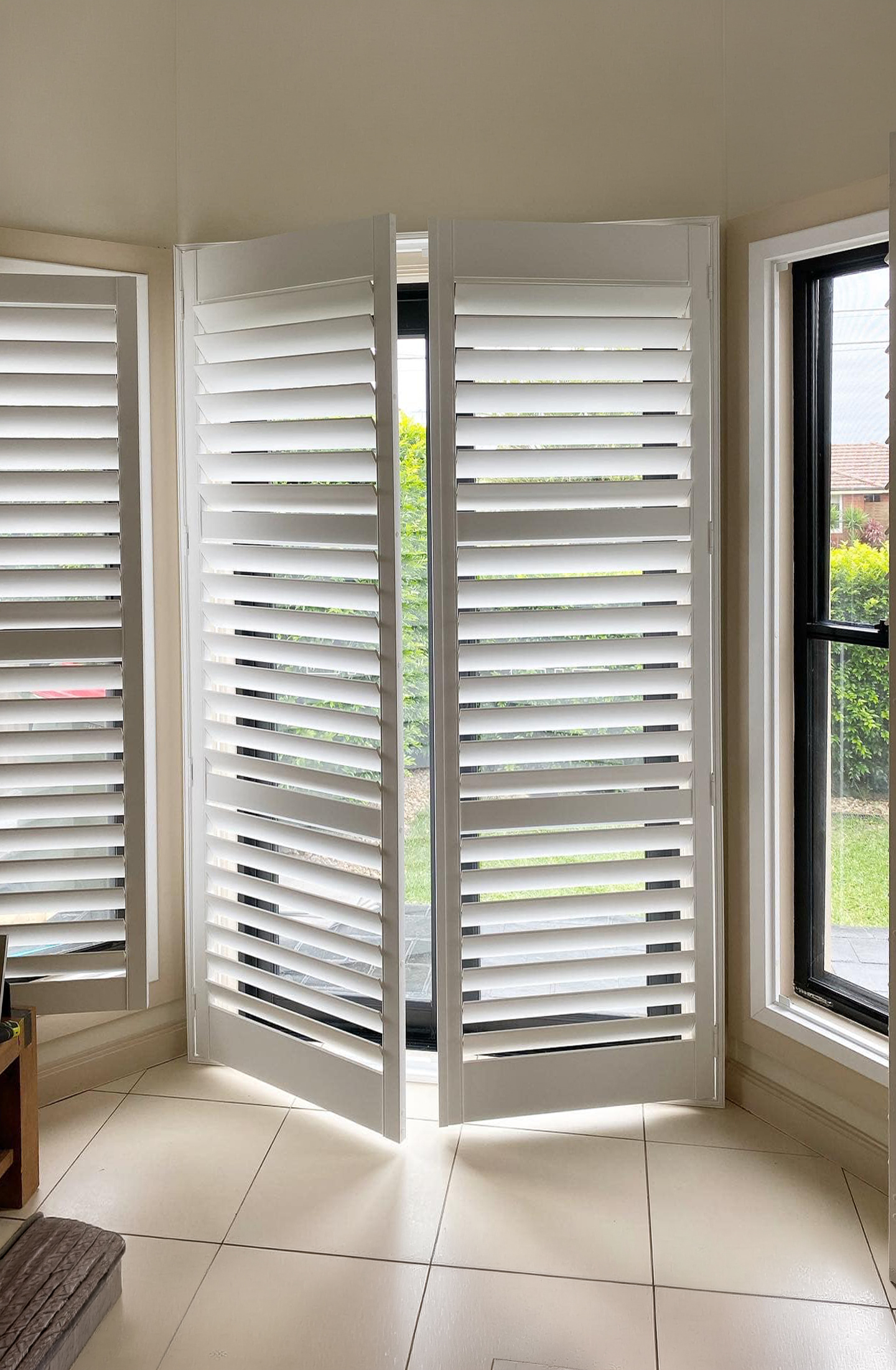 Plantation shutter doors on hinged doors in living room installed by Olsen Security