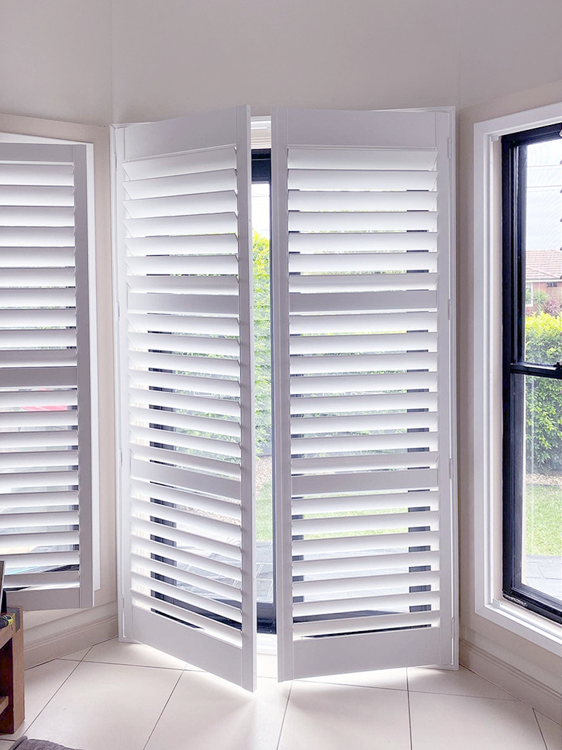 Plantation shutter doors on hinged doors in living room installed by Olsen Security