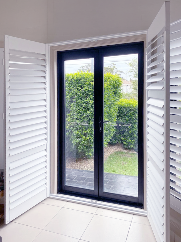 Plantation shutters, blinds, shades & privacy screens Plantation shutters doors on hinged doors in living room installed by Olsen Security