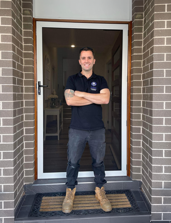 Nathan Olsen Director of Olsen Security standing in front of ScreenGuard security hinged front door.